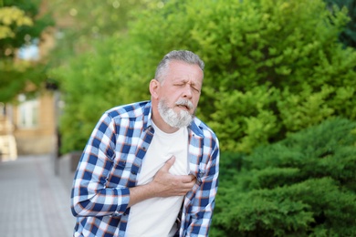 Photo of Mature man having heart attack, outdoors