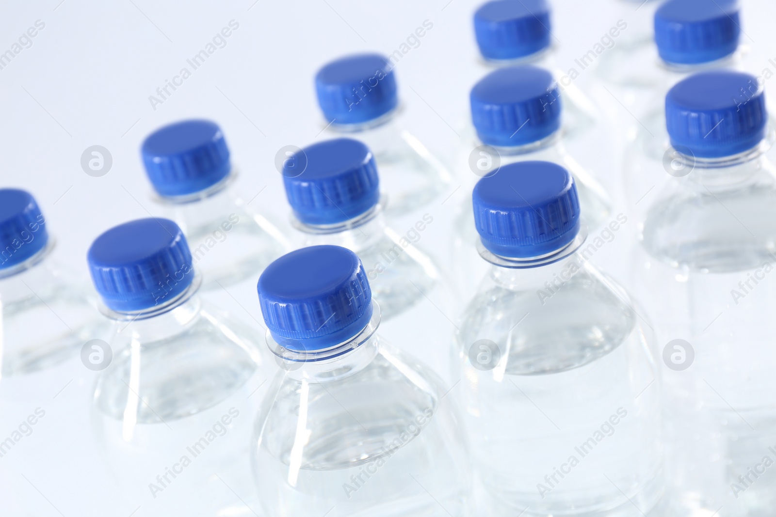 Photo of Plastic bottles with pure water on white background, closeup