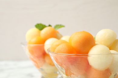 Photo of Delicious melon balls and mint in bowl, closeup