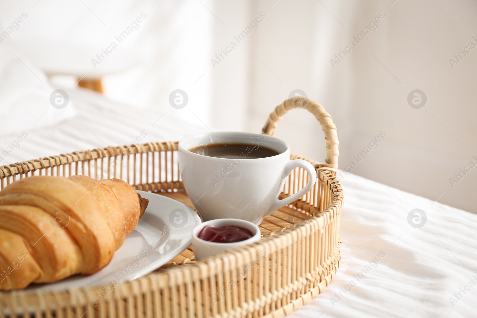 Photo of Tray with tasty breakfast on bed. Cozy morning