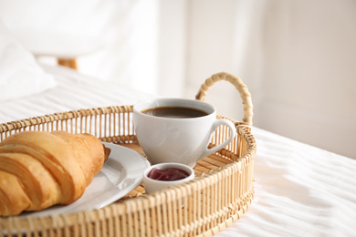 Photo of Tray with tasty breakfast on bed. Cozy morning