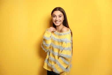 Photo of Beautiful young woman in warm sweater on color background