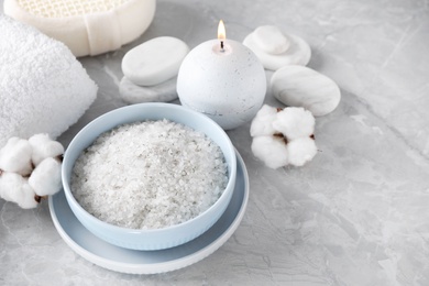Photo of Composition with white sea salt for spa scrubbing procedure on grey marble table