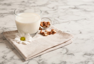 Photo of Glass with milk and nuts on light background