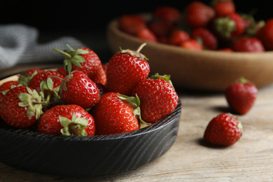 Photo of Delicious ripe strawberries on wooden plate, closeup