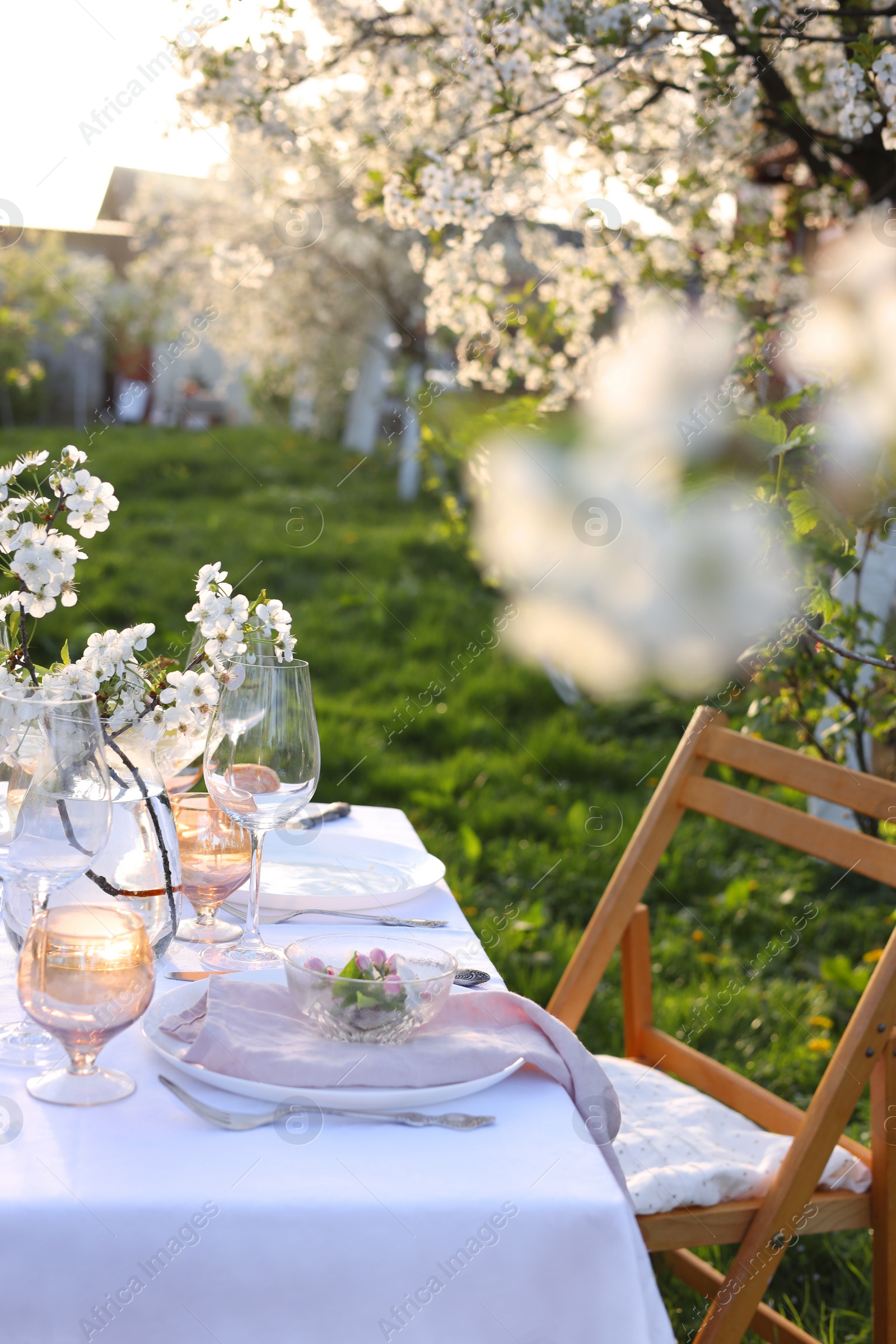 Photo of Stylish table setting with beautiful spring flowers in garden