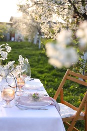 Photo of Stylish table setting with beautiful spring flowers in garden