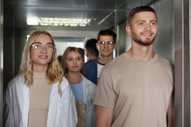 Photo of Group of young people in modern elevator