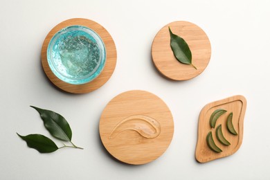 Photo of Flat lay composition with blue cosmetic gel and aloe on white background