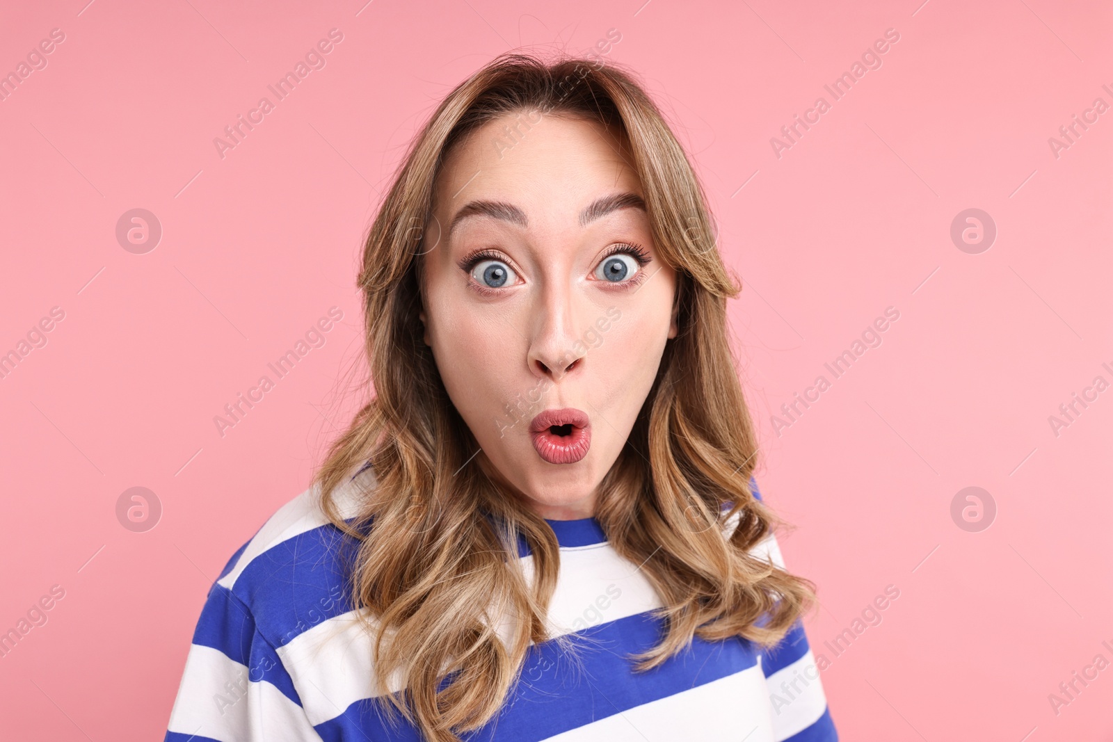 Photo of Portrait of surprised woman on pink background