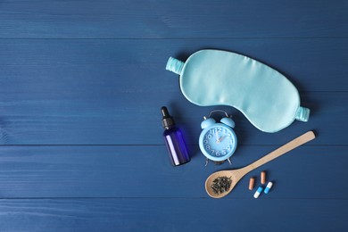 Photo of Alarm clock, sleeping mask and different remedies for insomnia treatment on blue wooden table, flat lay