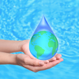 Image of Woman holding icon of Earth in water drop on blue background, closeup. Ecology concept