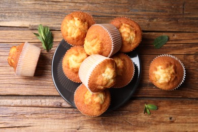 Photo of Delicious sweet muffins on wooden table, flat lay