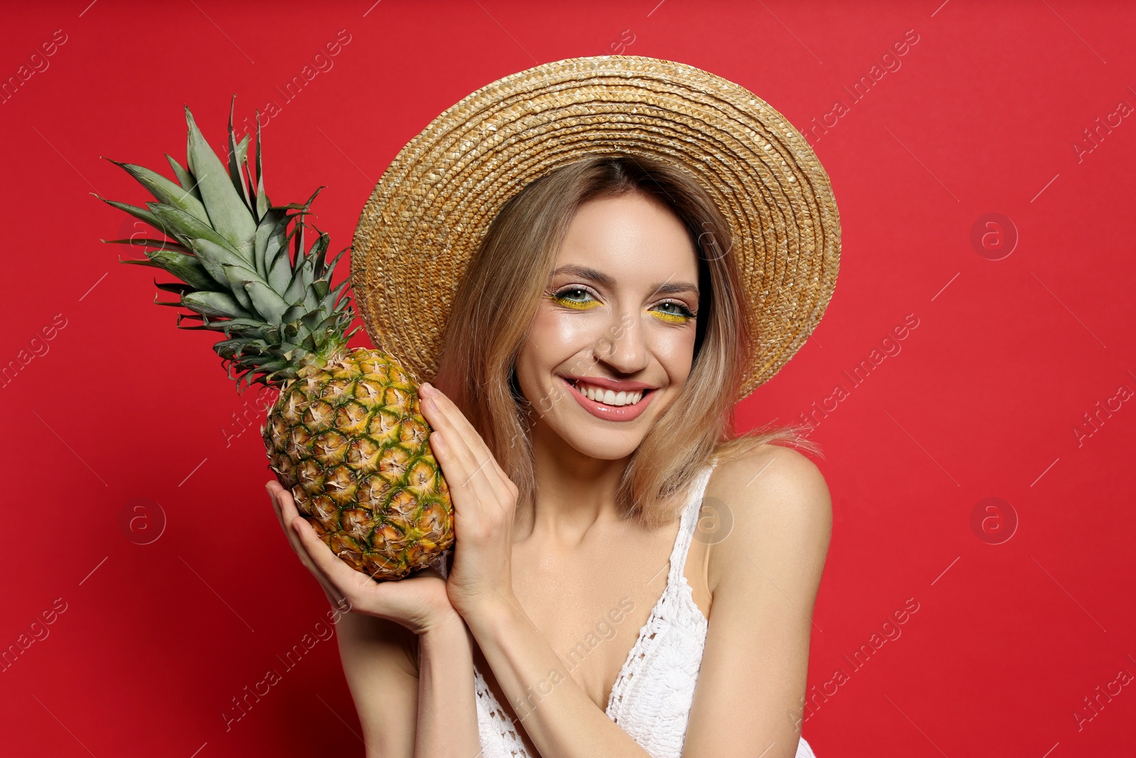 Photo of Young woman with fresh pineapple on red background. Exotic fruit