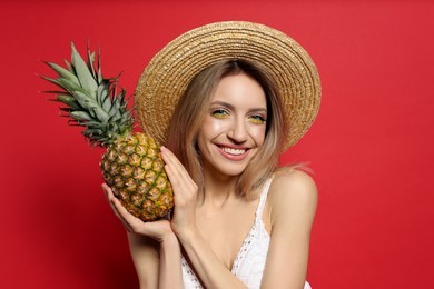 Photo of Young woman with fresh pineapple on red background. Exotic fruit