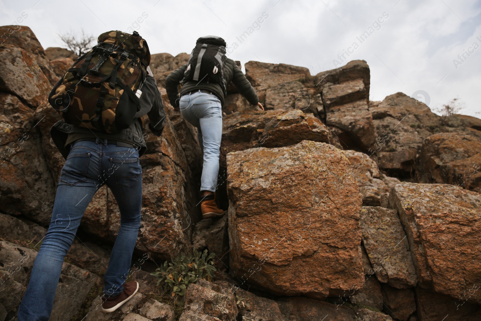 Photo of Hikers with backpacks climbing up mountains on autumn day