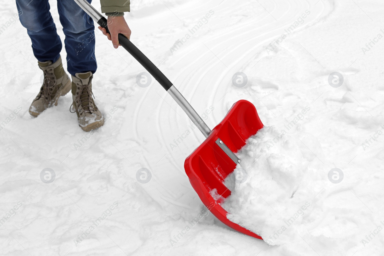 Photo of Man removing snow with shovel outdoors. Winter weather