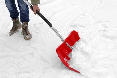 Photo of Man removing snow with shovel outdoors. Winter weather