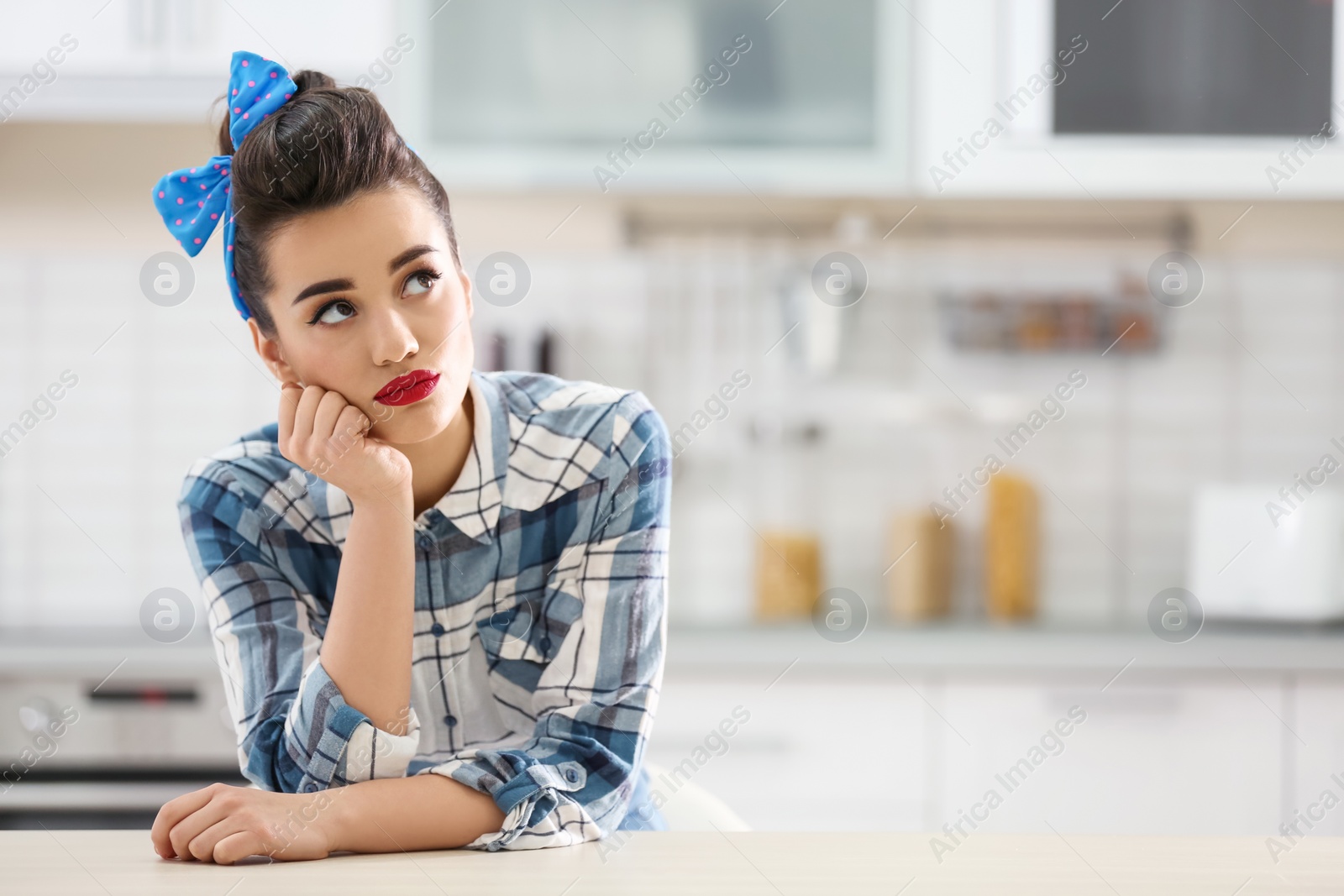 Photo of Portrait of funny young housewife in kitchen