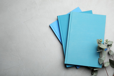 Stylish blue notebooks on light grey table, flat lay. Space for text