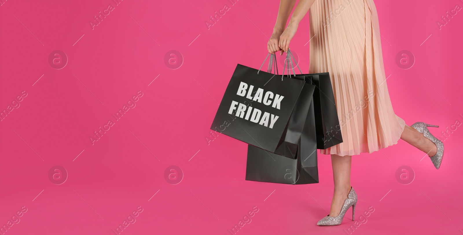 Photo of Woman with shopping bags on pink background, closeup. Black Friday Sale