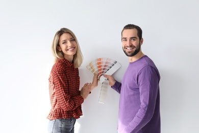 Photo of Young couple with color palette on white background