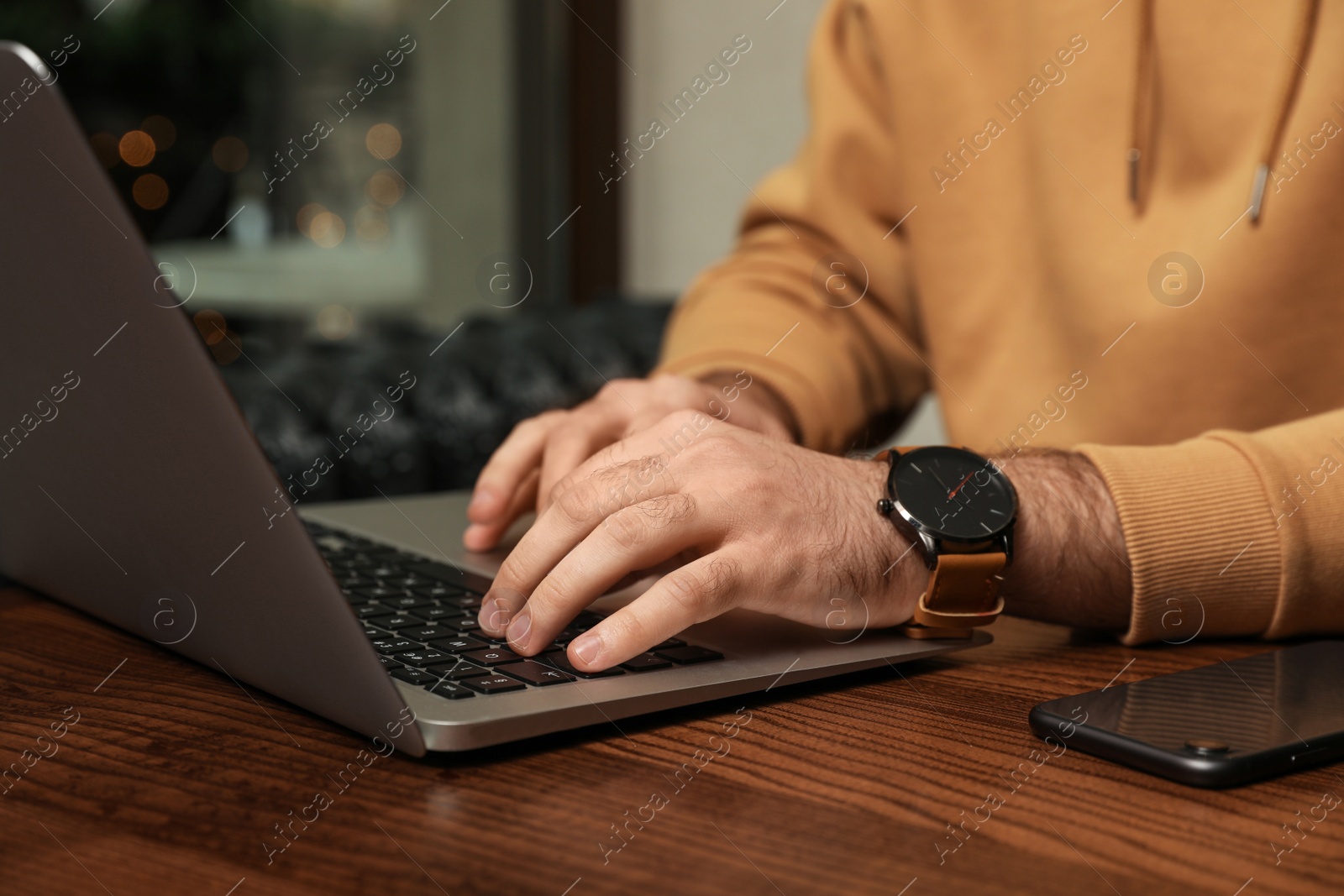 Photo of Male blogger working with laptop at table in cafe, closeup