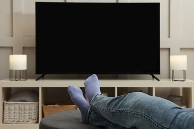 Woman watching TV in living room, closeup