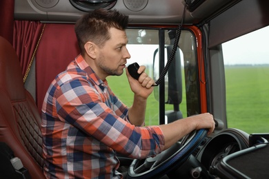 Photo of Driver using CB radio in cab of modern truck