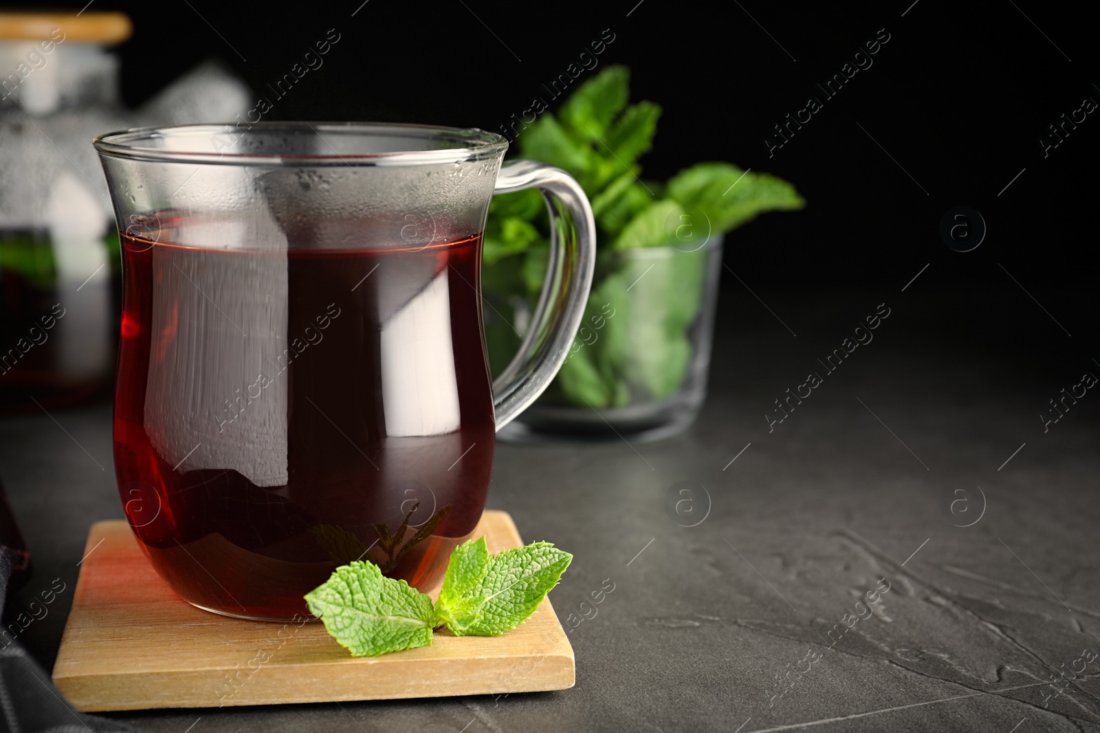 Photo of Fresh tea with mint on grey table, closeup. Space for text