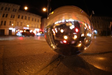 Photo of Crystal ball on asphalt road at night. Wide-angle lens