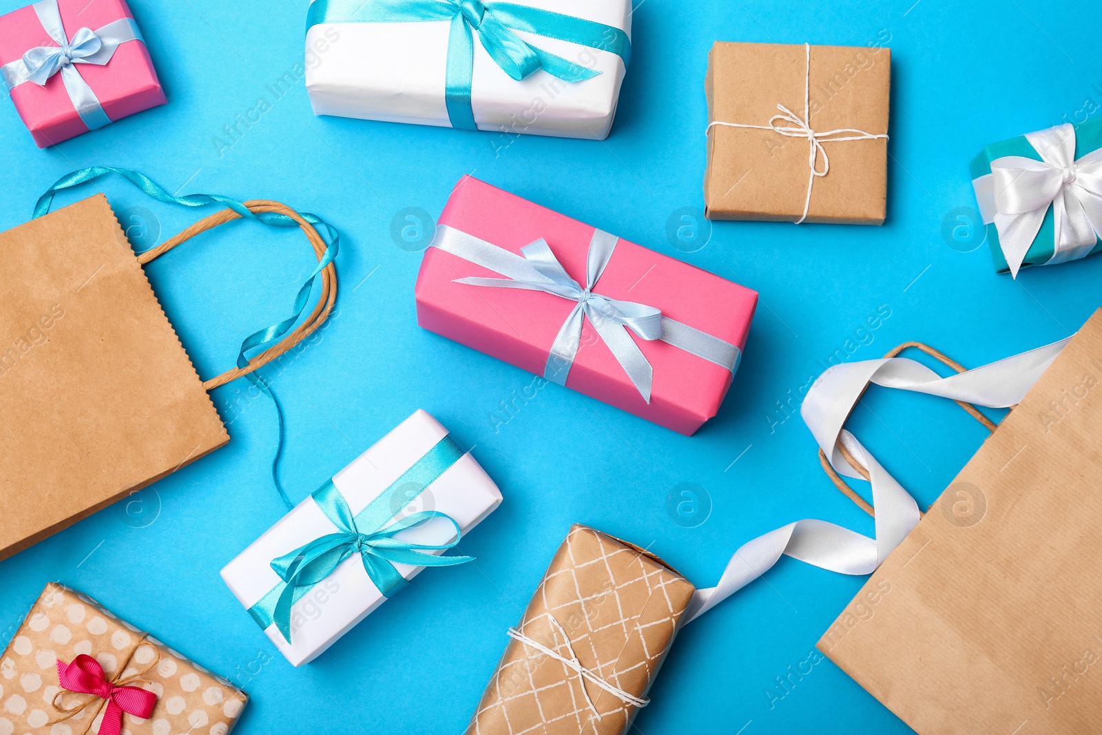 Photo of Flat lay composition with shopping bag and gifts on color background