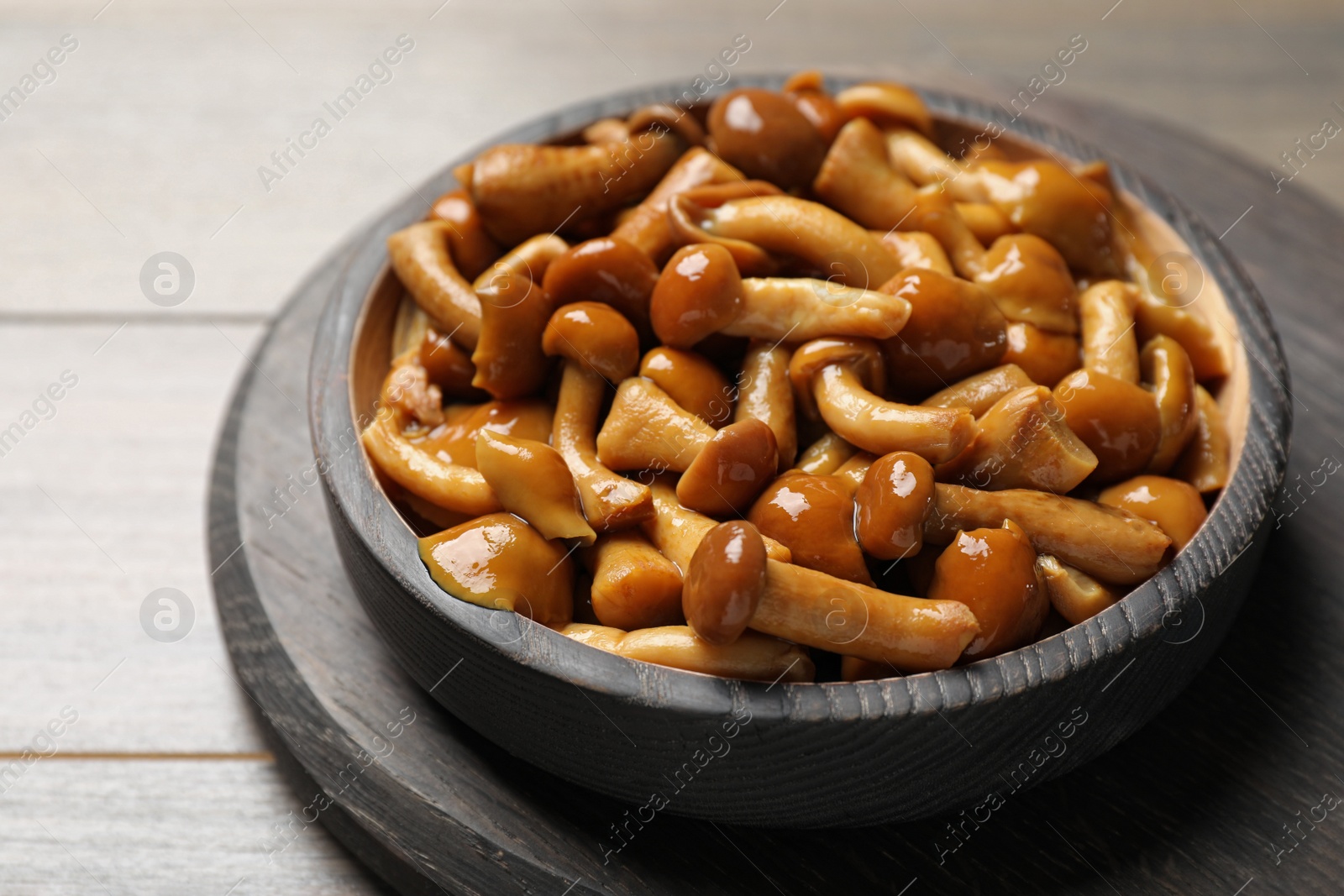 Photo of Delicious marinated mushrooms on wooden table, closeup