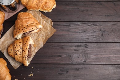 Fresh croissants with chocolate on wooden table, flat lay. Space for text