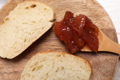 Photo of Delicious apple jam and bread slices on white wooden table, top view