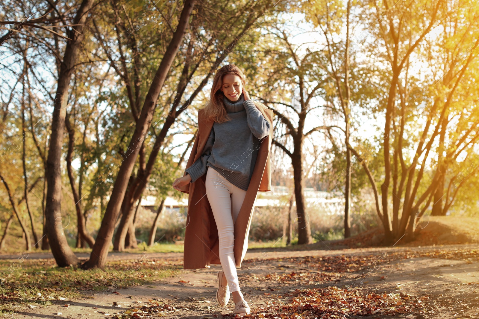 Photo of Beautiful young woman wearing stylish clothes in autumn park