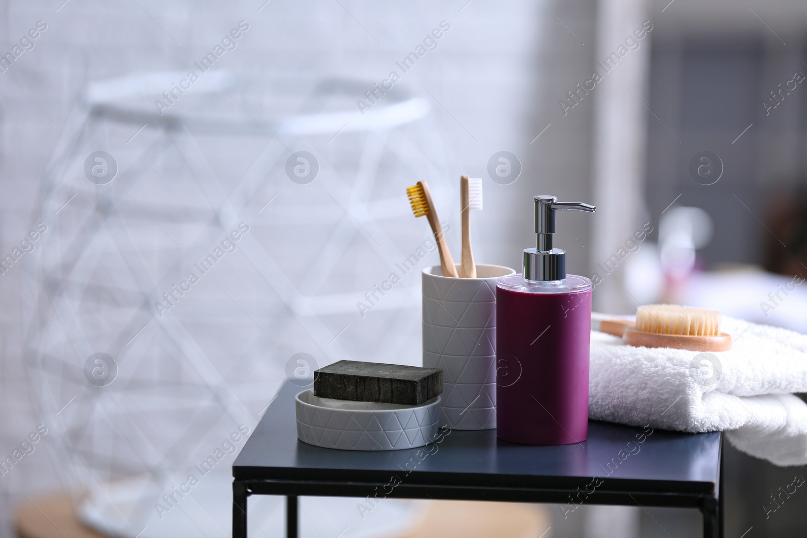 Photo of Aromatic soap and toiletries on table against blurred background. Space for text