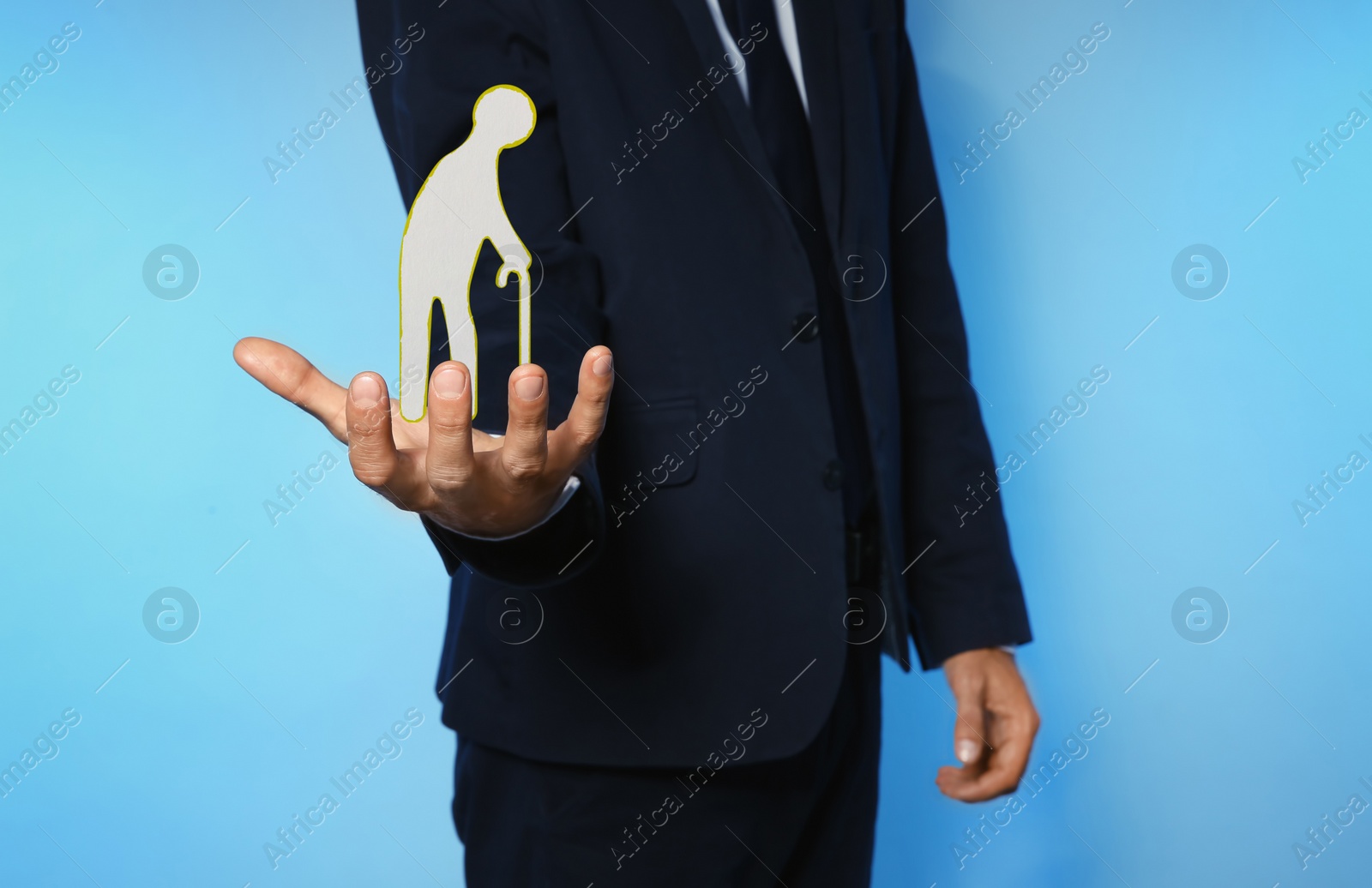 Image of Man demonstrating image of elderly person on light blue background, closeup. Retirement concept