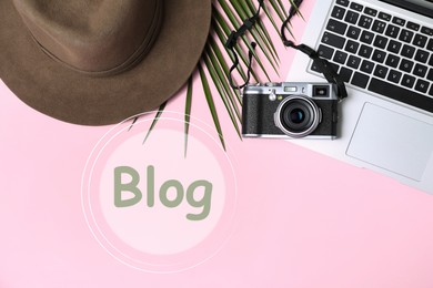 Image of Blogger's workplace with laptop and camera on pink background, flat lay