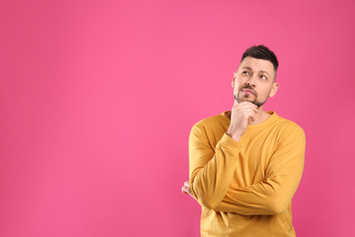 Emotional man on pink background, space for text