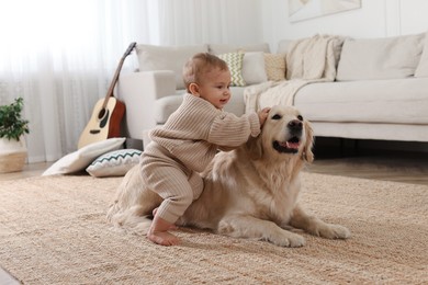 Photo of Cute little baby with adorable dog on floor at home