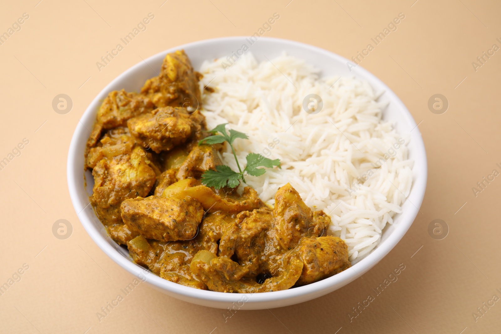 Photo of Delicious chicken curry with rice on beige background, closeup