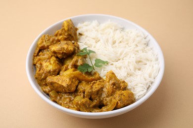 Photo of Delicious chicken curry with rice on beige background, closeup