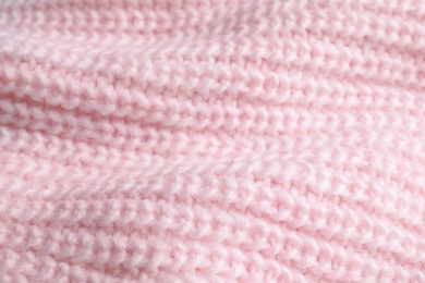 Pink knitted sweater as background, closeup view