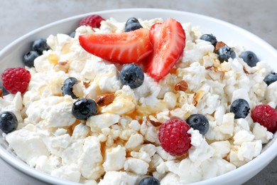 Delicious cottage cheese with fresh berries in bowl, closeup. Tasty breakfast