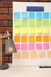 Photo of Business process planning and optimization. Workplace with colorful paper notes and lamp on table