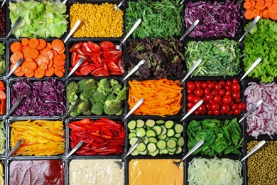 Salad bar with different fresh ingredients as background, top view