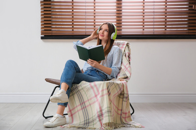 Woman listening to audiobook in chair at home