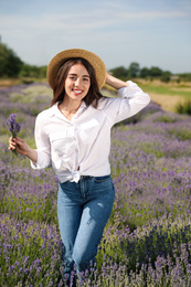 Young woman with lavender bouquet in field on summer day