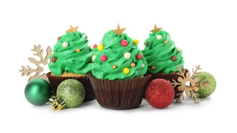 Photo of Tasty Christmas tree cupcakes and festive decor on white background